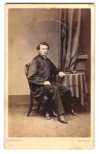 Fotografie E. Gottheil, London, englischer Herr im dunklen Anzug sitzend am Tisch
