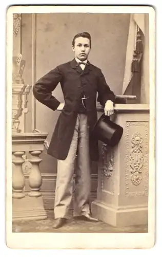 Fotografie George Heyer, Osnabrück, junger Mann im Anzug mit Fliege und Zylinder posiert im Atelier