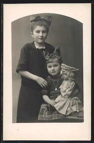 Foto-AK Junges Mädchen mit grosser Schleife und Puppe auf dem Arm