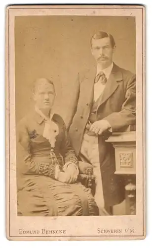 Fotografie Edmund Behncke, Schwerin, Wismarschestr. 26, Junges bürgerliches Paar in eleganter Kleidung mit starrem Blick