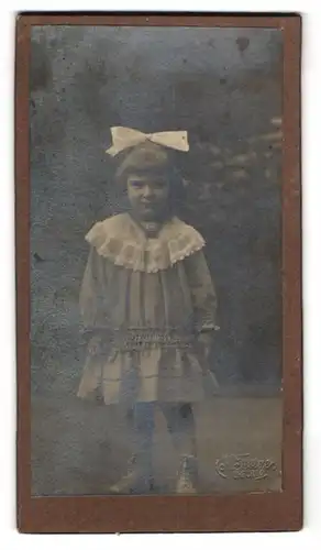 Fotografie K. Festger, Erfurt, Niedliches Mädchen im Kleid mit weisser Schleife im Haar