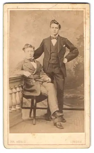 Fotografie Fr. Hüsig, Lingen, Junge gutaussehende Herren in dunklen Anzügen mit Tolle und Fliege