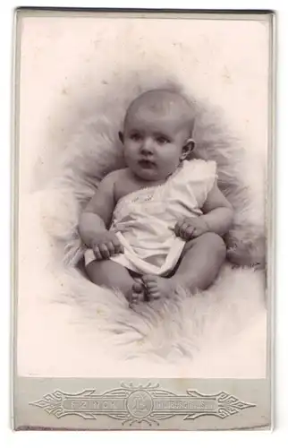 Fotografie F. Zinck, Hildburghausen, Niedliches Baby auf einem weissen Fell