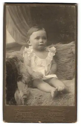 Fotografie Alfred Richter, Radebeul, Kleinkind mit gescheiteltem Haar auf Fell