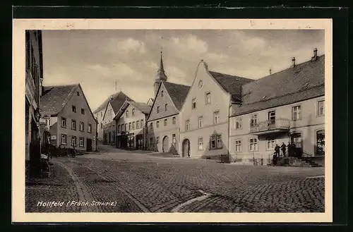 AK Hollfeld /Fränk. Schweiz, Strassenpartie mit Wohnhäusern und Blick zur Kirche