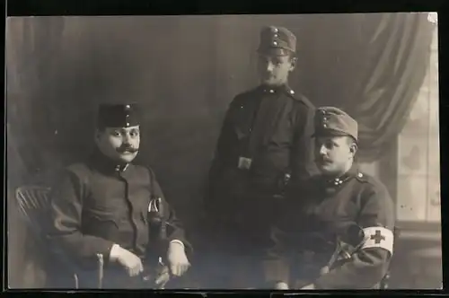 Foto-AK Drei österreichische Soldaten in Uniform, Rotes Kreuz