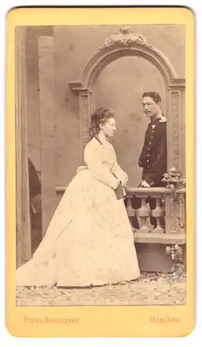 Fotografie Franz Neumayer, München, Soldat in Uniform mit Orden an der Brust nebst seiner Frau, Kriegsausmarsch, Kulisse