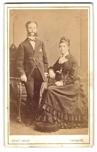 Fotografie Franz Julius, Hamburg, Grosse Bleichen 31, Feiner Herr mit Backenbart und Dame mit schwarzem Kleid