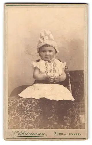Fotografie L. Christensen, Burg auf Fehmarn, Kleines Mädchen mit niedlicher Mütze