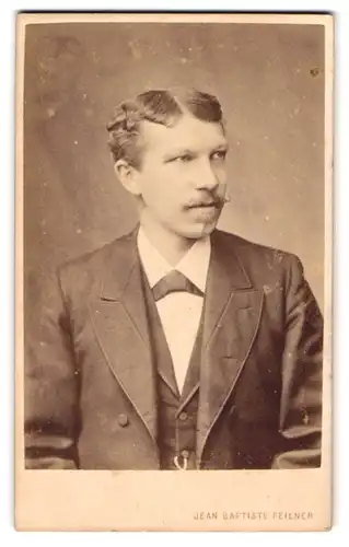 Fotografie Jean Baptiste Feilner, Bremen, Wall 185, Junger Herr im schwarzen Anzug mit Fliege und Schnurrbart