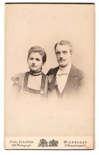 Fotografie Karl Schipper, Wiesbaden, Rheinstr. 31, Junges Paar in Kleid und Anzug mit Brosche und Fliege