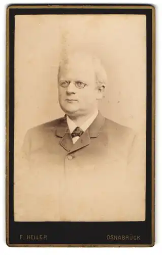 Fotografie F. Heiler, Osnabrück, Grosse Str. 28, Beleibter Herr im schwarzen Anzug mit weissem Haar und Brille