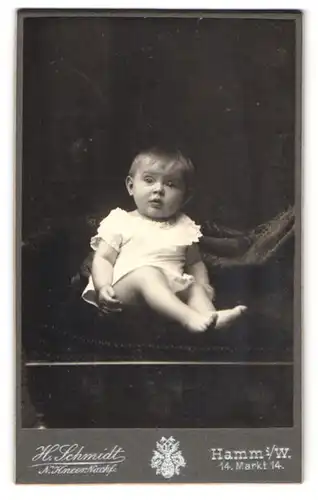 Fotografie Heinr. Schmidt, Hamm i. W., Markt 14, Süsses Kleinkind im Hemd mit nackigen Füssen
