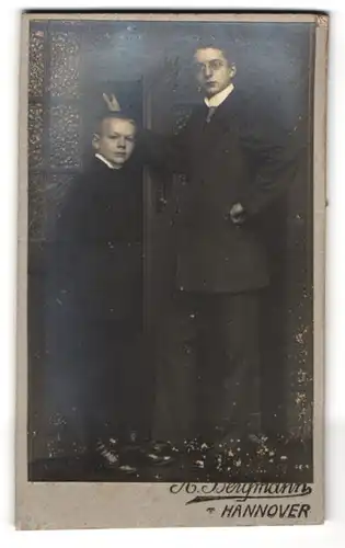 Fotografie Bergmann, Hannover, Junger Mann mit Nickelbrille und dunkelblonder Junge lässig posierend