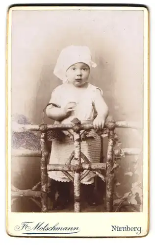 Fotografie F. Motschmann, Nürnberg, Maxfeld-Str. 48, Niedliches kleines Mädchen mit skeptischen Blick und Kopfbedeckung