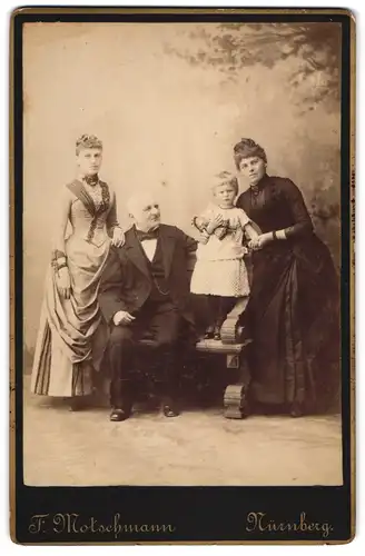 Fotografie F. Motschmann, Nürnberg, Maxfeldstr. 48, Älterer eleganter Herr und zwei junge Frauen mit Kind