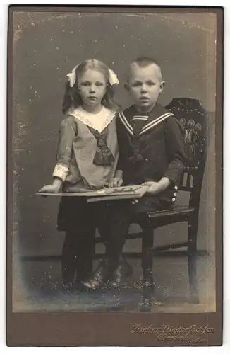 Fotografie Atelier Niedersachsen, Verden /Aller, Modisch gekleidetes Kinderpaar mit Bilderbuch