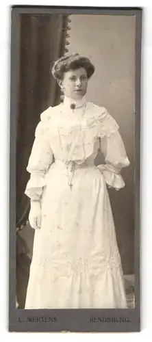 Fotografie L. Mertens, Rendsburg, Dame im weissen Kleid und langer Kette mit Kreuz