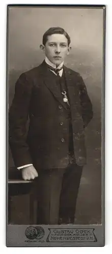Fotografie Gustav Gock, Hohenwestedt i. H., Junge mit Segelohren im Anzug mit Krawatte und Kette