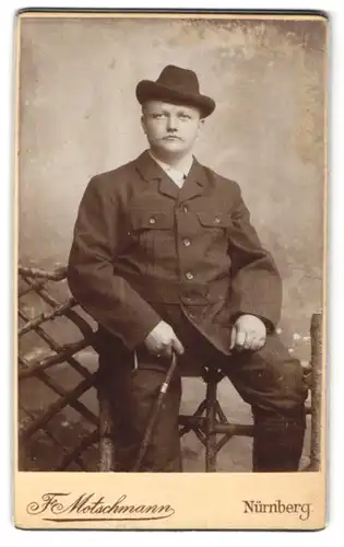 Fotografie F. Motschmann, Nürnberg, Maxfeld-Strasse 48, Kräftiger junger Mann mit Hut und Stock