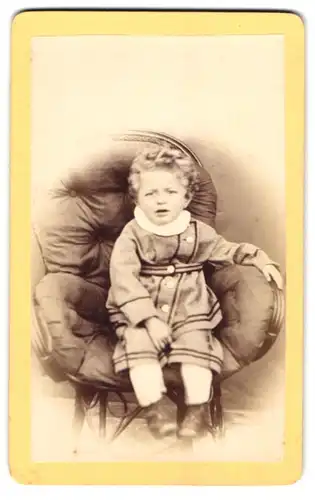 Fotografie unbekannter Fotograf und Ort, Niedlicher Junge in heller Kleidung mit weissem Kragen auf einem Sessel
