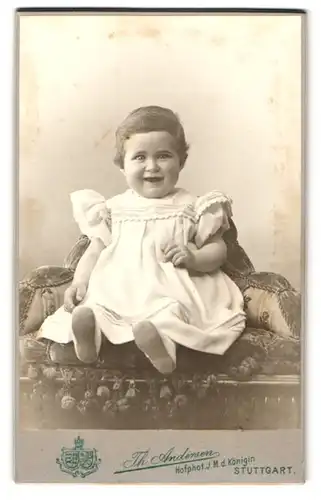 Fotografie Th. Andersen, Stuttgart, Charlottenstr. 8, Niedliches erfreutes Kleinkind im weissen Kleid mit süssen Bäckchen