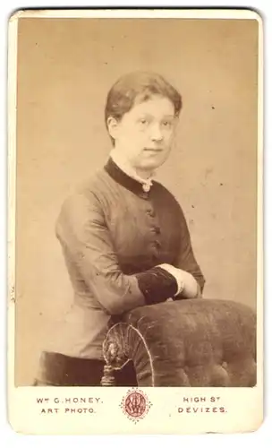 Fotografie Wm. G. Honey, Devizes, High St., Junge Frau im taillierten geknöpften Kleid mit heller Brosche