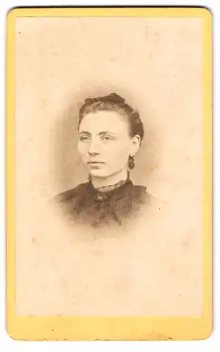 Fotografie A. F. Knoop, Eutin, Junge Dame im schwarzen Kleid mit Ohrring und hochgestecktem Haar