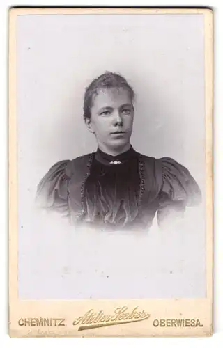 Fotografie Atelier Seeber, Chemnitz, Theaterstr. 22, Junge Frau im schwarzen Kleid mit puffigen Ärmeln und Brosche