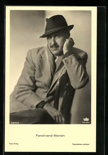 AK Schauspieler Ferdinand Marian mit Hut auf einem Stuhl sitzend