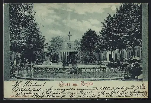 Mondschein-AK Krefeld, Passanten am Springbrunnen