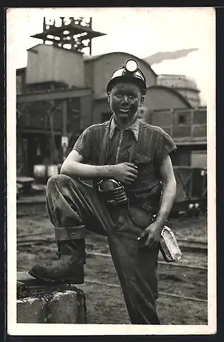 AK Bergmann mit Helmlampe und verdrecktem Gesicht über Tage