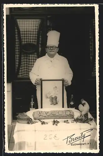 Foto-AK Koch mit einem Bild am Tisch