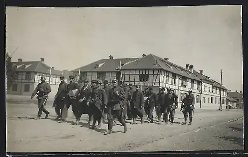 Foto-AK Grafenwöhr, Kriegsgefangenen-Lager, Die Gefangenen laufen von Soldaten flankiert durch den Ort