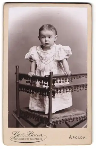Fotografie Gustav Bauer, Apolda, kleines Mädchen steht im Kleid auf einem Stuhl
