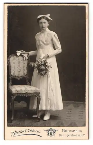 Fotografie Atelier Viktoria, Bromberg, Danzigerstrasse 157, junge Frau steht in weissem Kleid neben einem Stuhl