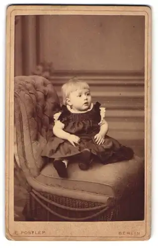 Fotografie E. Postlep, Berlin, Chausseestr. 5, kleines Mädchen sitzt in schwarzem Kleid auf einem Stuhl
