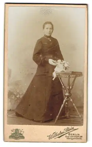 Fotografie Wilhelm Stein, Berlin, Chausseestr. 66, Gutaussehende brünette Dame mit Kette und Blumenstrauss