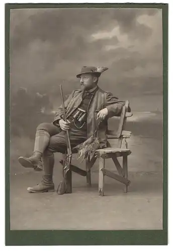 Fotografie unbekannter Fotograf und Ort, Jäger mit Flinte und erlegten Fasanen sitzt auf einer Bank, Fernglas