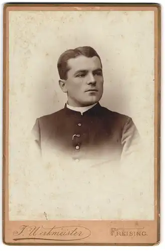 Fotografie J. Werkmeister, Freising, junger Pastor im Talar mit Collar