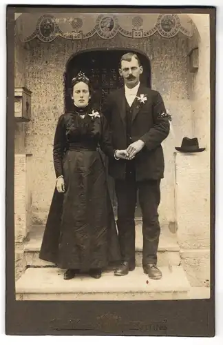 Fotografie Hans Strauss, Altötting, Hochzeitspaar im schwarzen Kleid und Anzug vor der Kapelle