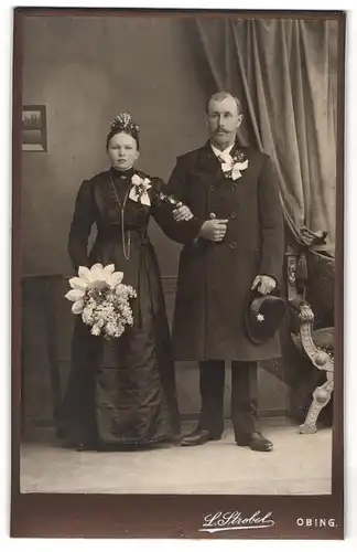 Fotografie L. Strobel, Obing, Brautpaar im schwarzen Hochzeitskleid und im Anzug mit Brautstrauss