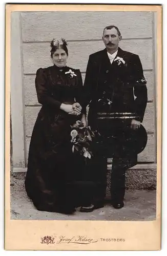 Fotografie Josef Käser, Trostberg, Eheleute im schwarzen Brautkleid und Anzug mit Brautstrauss