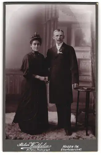 Fotografie Atelier Westfalia, Hagen i. W., junge Eheleute mit schwarzen Brautkleid und im Anzug