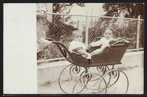 Foto-AK Zwei niedliche Kinder sitzen in einem Kinderwagen