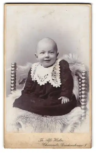 Fotografie Th. Alfred Hahn, Chemnitz, Brückenstr. 5, Süsses Kleinkind im Kleid sitzt auf Fell