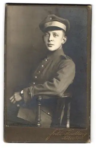 Fotografie Fritz Härthey, Lüben i. Schl., junger Soldat in Uniform mit Schirmmütze