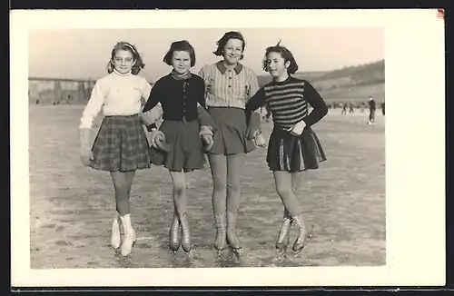 AK Vier hübsche Mädchen in kurzen Röcken und mit Schlittschuhen