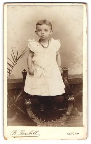 Fotografie R. Przibill, Altona, Reichenstr. 18, Kind im weissen Kleid mit Halskette