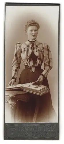 Fotografie Hermann Tietz, Hamburg, Gr. Burstah, Junge Dame in karierter Bluse mit Album